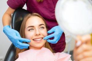 Putney Dentist 29 dentist demonstrates the perfect smile of the patient after implatation of dental veneers