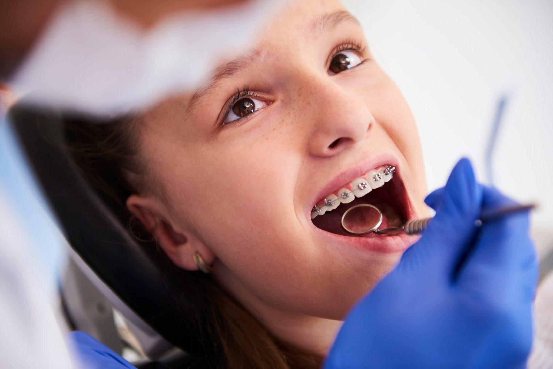 girl with braces during a routine dental examination girl with braces during a routine dental examination