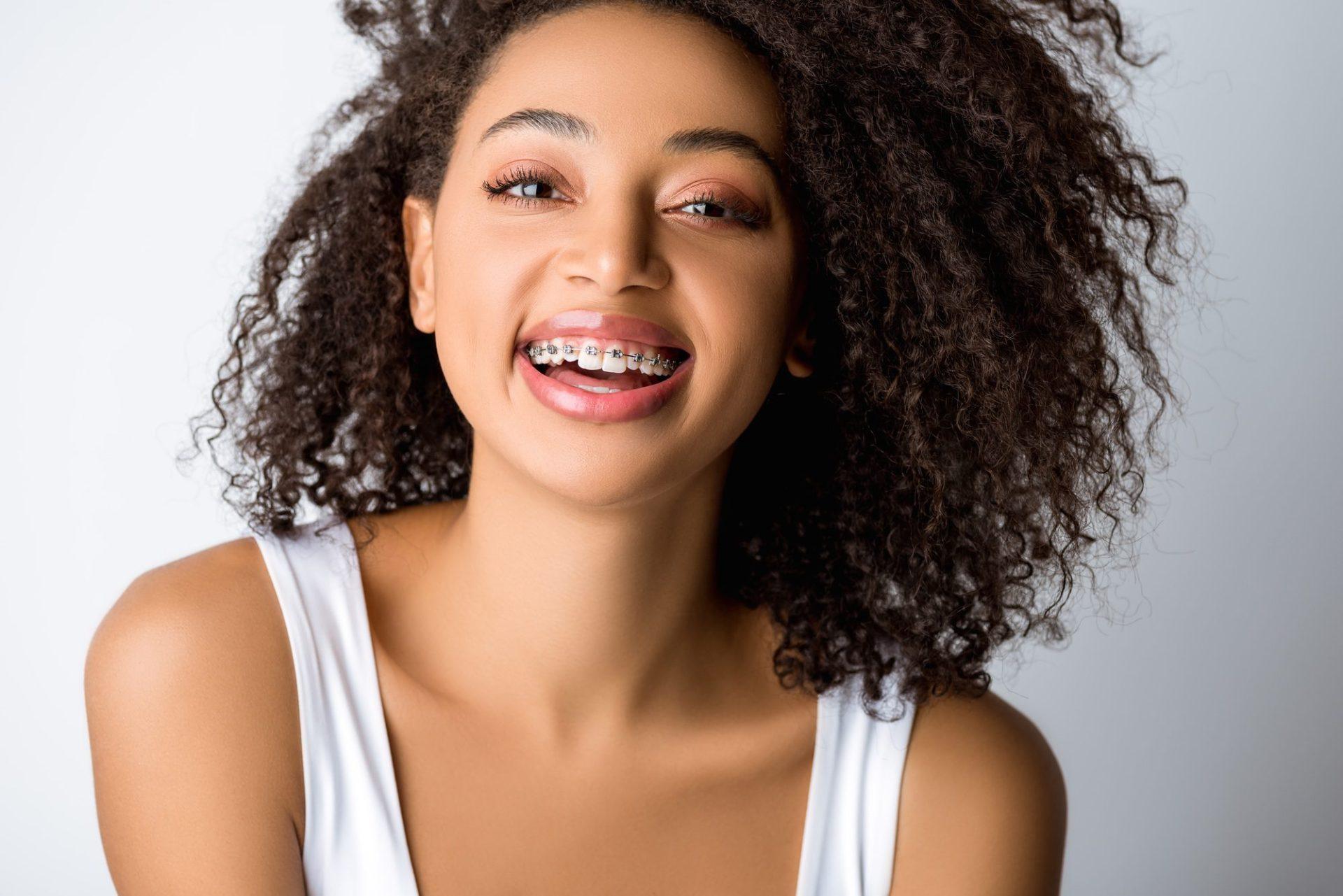 laughing african american girl with dental braces isolated on grey laughing african american girl with dental braces isolated on grey