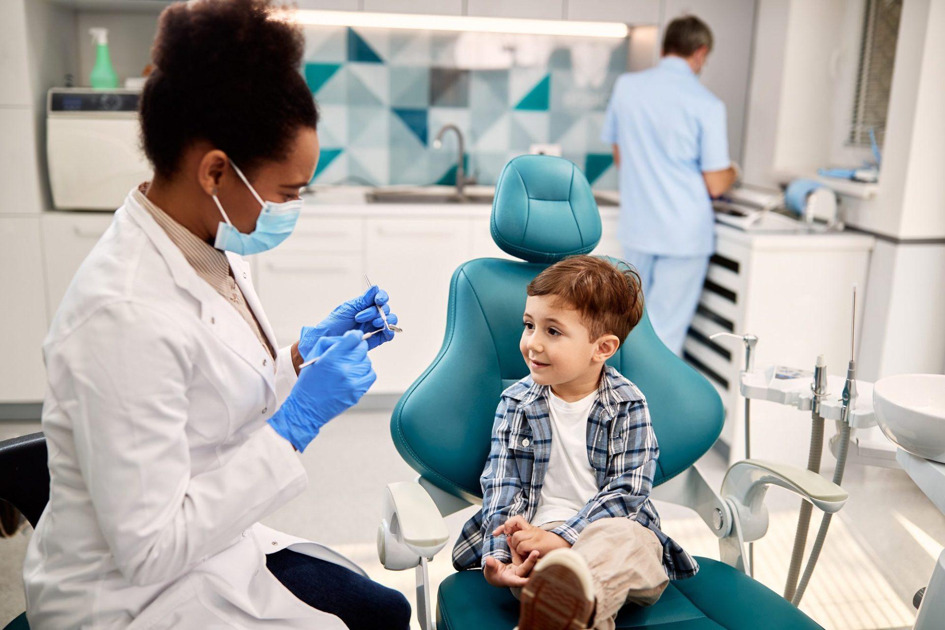Child Dental Benefits Schedule 20 small boy talking to dentist before teeth examination at dentist s office