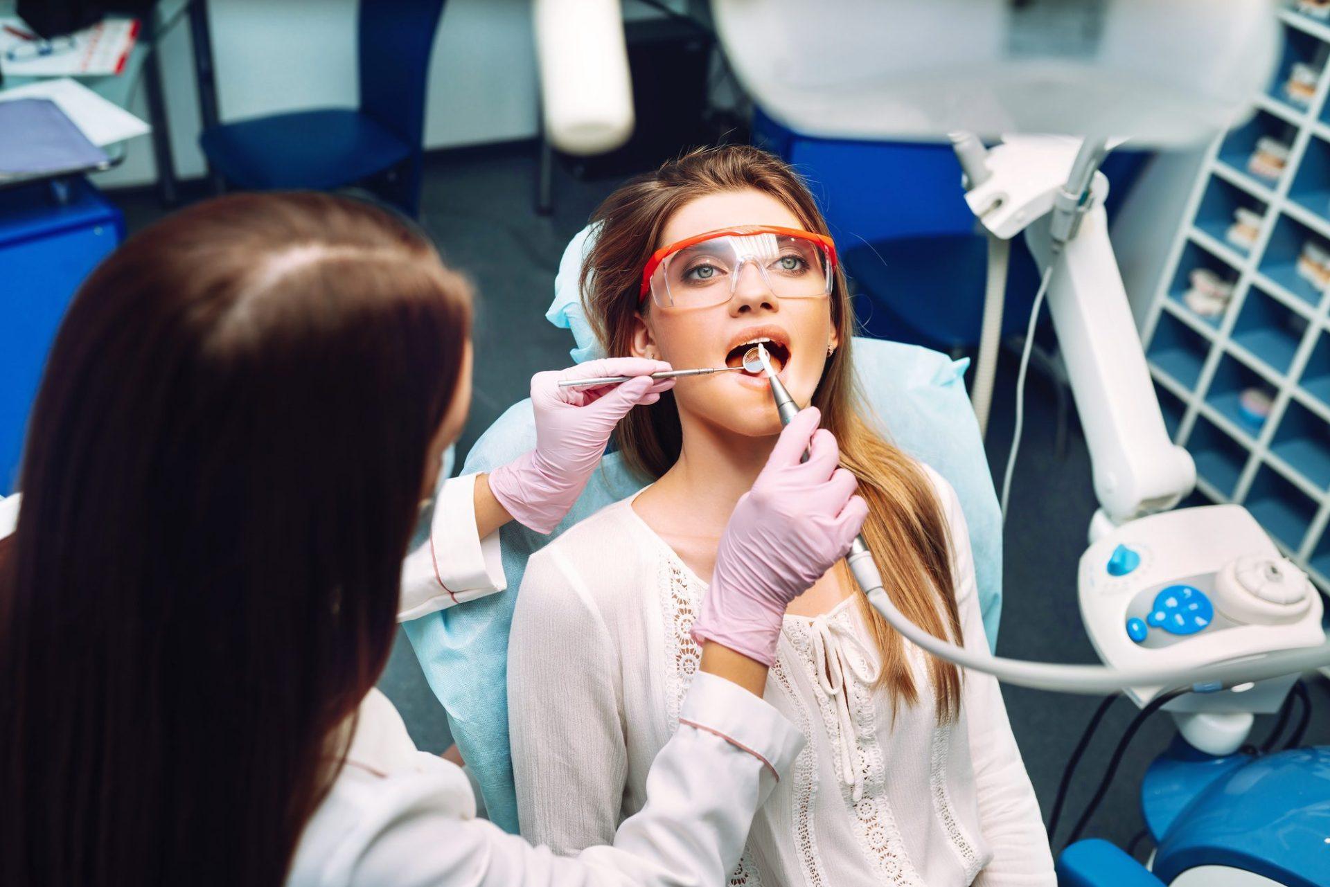 young woman at the dentist s chair during a dental procedure overview of dental caries prevention young woman at the dentist s chair during a dental procedure overview of dental caries prevention