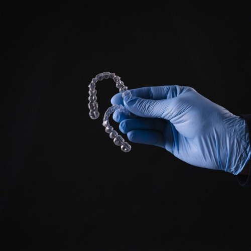 Sports Mouthguards 16 closeup of hand in gloves holding transparent mouthguards isolated on black background